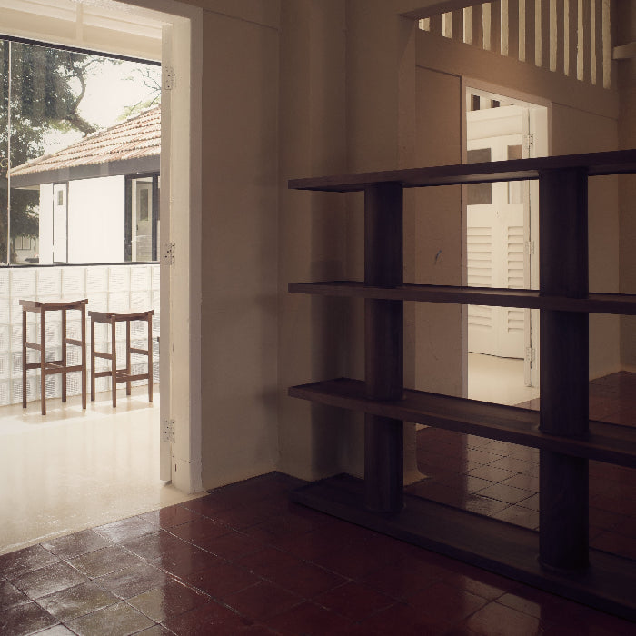 Interior room with a bookshelf, tiled floor, and open door leading to another room.