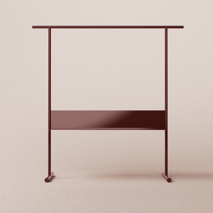 Metallic clothing rack with a shelf on a beige background
