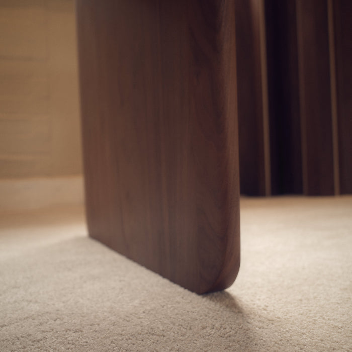 Close-up of a wooden leg on a carpeted floor