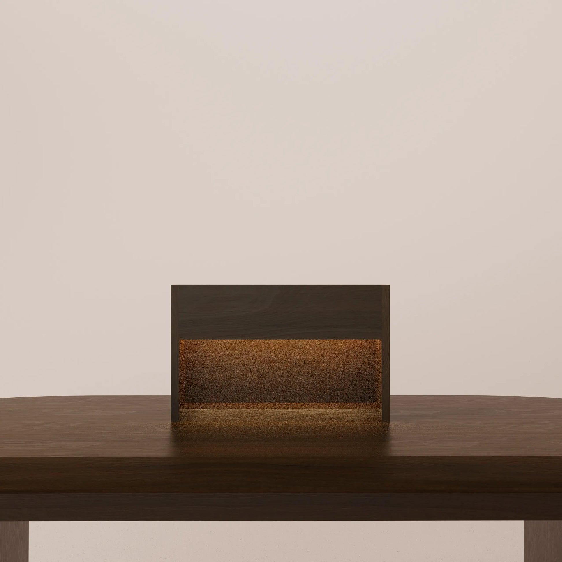 Solid walnut table lamp with a warm glow on a wooden surface against a beige wall