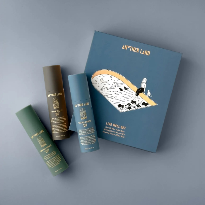 Set of 'Another Land' skincare products on a gray background