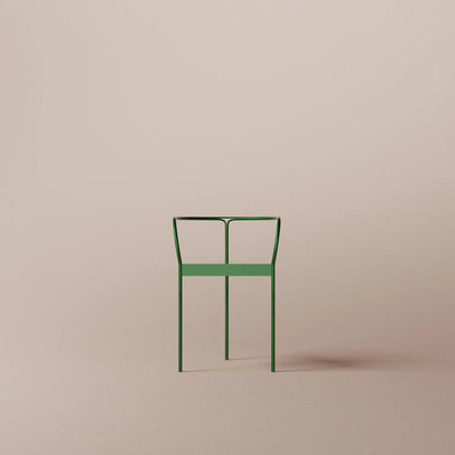 Green metal chair on a beige background