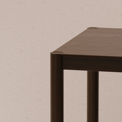Solid walnut rectangular table corner on a beige background