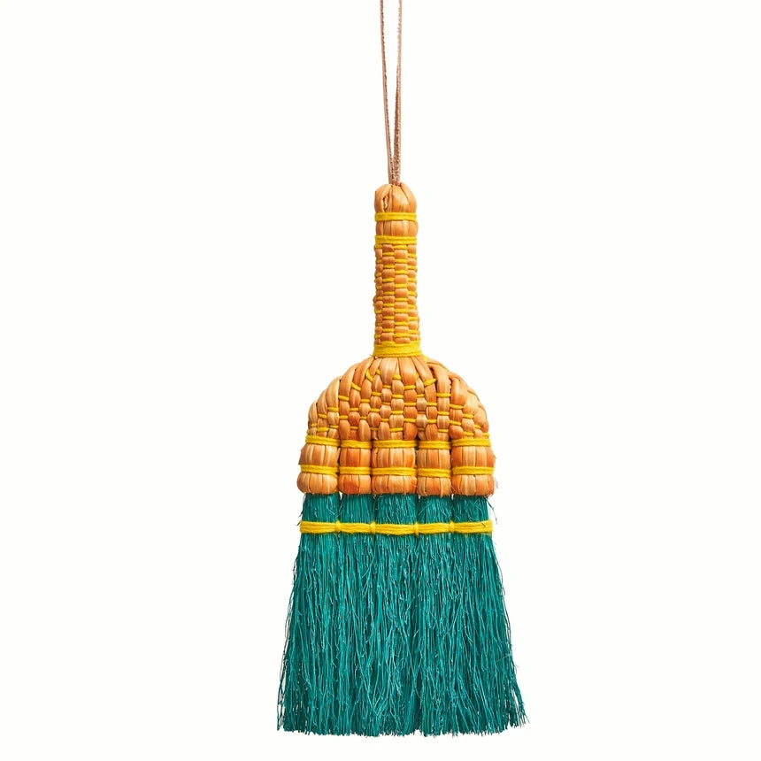 Decorative broom with a yellow handle and green bristles on a white background